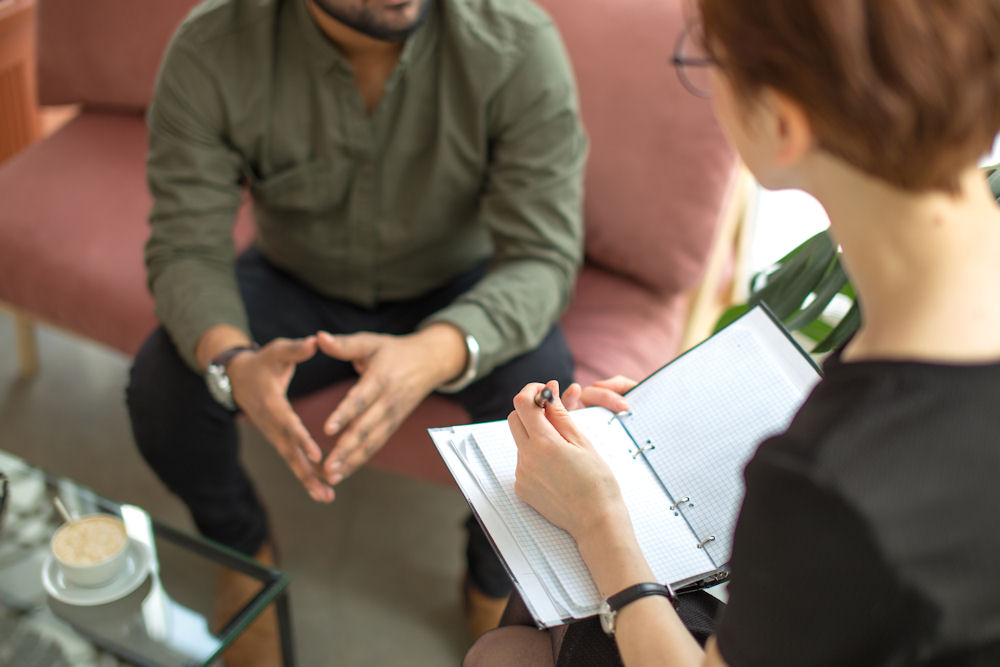 Therapist using Motivational Interviewing techniques during a one-on-one counseling session with a client